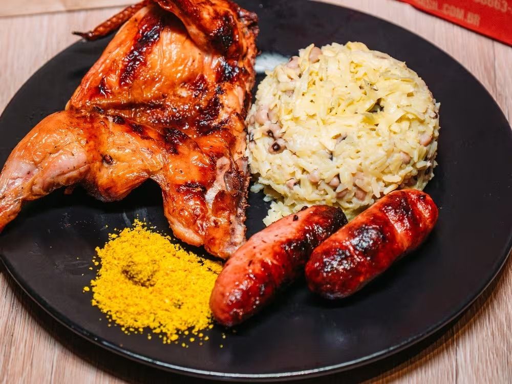 Meio galeto na brasa com baião de dois, linguiças e farofa amarela
